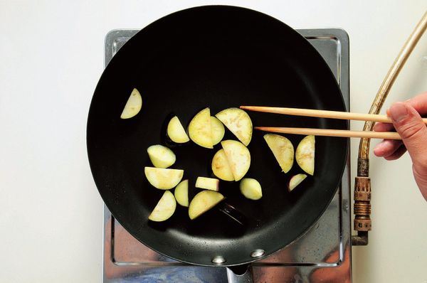 茄子切成1cm寬的半圓形，將油倒入平底鍋以中火加熱，再將茄子快速拌炒幾下後盛出。
