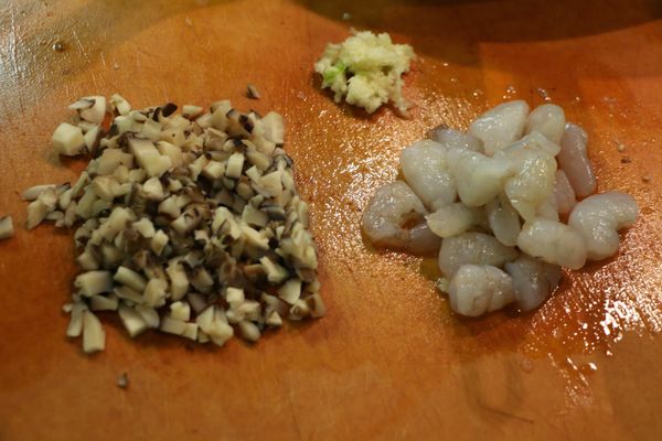 將泡軟的香菇切粒；蝦仁切粒；蒜切末。