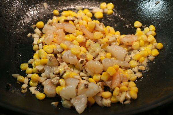 炒鍋中加少許油燒熱，放入蒜末爆香後，加入香菇、蝦仁和粟米翻炒，下少許鹽和雞粉調味。炒至蝦仁熟透後，將所有材料盛起，備用。