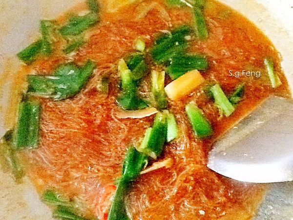 粉絲、蔥葉加入湯汁中，粉絲煮至軟熟，湯汁約收至九成乾，起鍋盛於盤底。