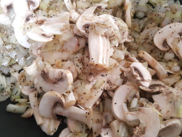 放入蘑菇加入黑胡椒粉一起拌炒