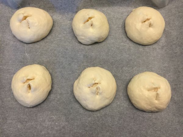 將麵包放在鋪好烤盤紙的烤盤上，進行二次發酵40分鐘，待麵糰膨脹至兩倍大；用廚房剪刀，在麵包表面剪出十字切口