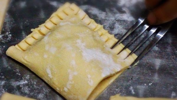 等起酥皮回軟（太硬折了會裂開）對折，用叉子將邊緣壓緊