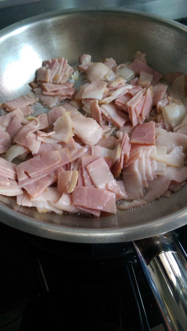 將培根切丁，倒入少許橄欖油煎煮。