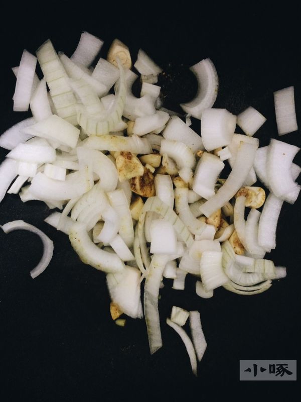 蒜頭 跟油放入平底鍋開火，讓油慢慢熱，提升蒜頭的香氣，放入一小匙咖哩粉與洋蔥，轉中火拌炒，待其軟化，變成焦糖色。此步驟需要較久的時間，且需一直待在鍋邊，避免燒焦。