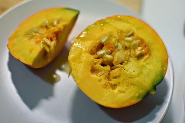 南瓜淋上橄欖油後，先放入烤箱180度C烤25分鐘後取出，放入鍋中一起再煮20分鐘。