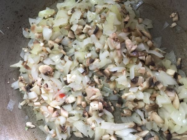 炒鍋中放入一匙奶油，炒香切碎的洋蔥、蘑菇並加鹽、胡椒調味備用