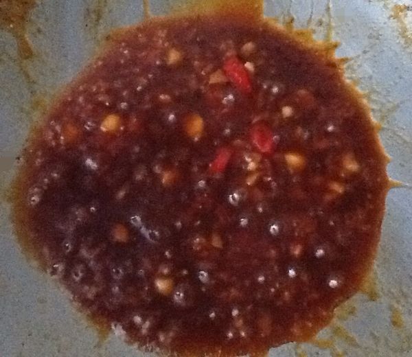 以鍋中之餘油，放入蒜、辣椒先炒香，加入調味料，煮滾後放入九層塔，翻炒至轉綠即可舀起淋在煎好的豆包上。