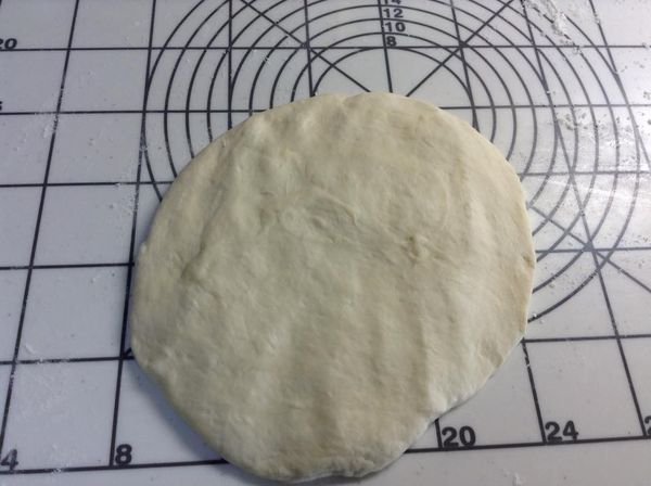 隔塑膠袋先輕壓排氣之後，拿出麵團，用手推壓成麵皮狀。