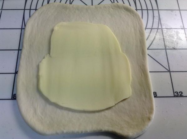 將麵團桿成約寬20公分和長20公分的麵皮，厚約0.8公分。

將奶油從冰箱取出後，放置正中央。