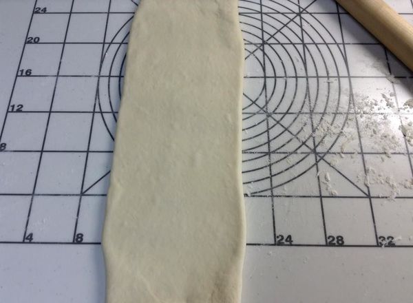 推桿成長條型麵皮，如果奶油不小心跑出來，就要用刷毛沾麵粉，將破口刷上麵粉。
