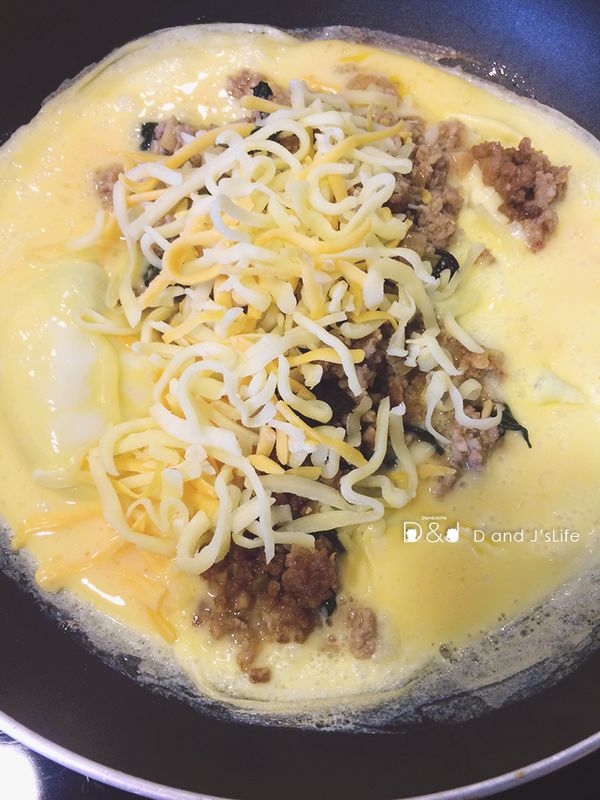 蛋液差不多熟時，熄火，放入泰式打拋豬與起司絲