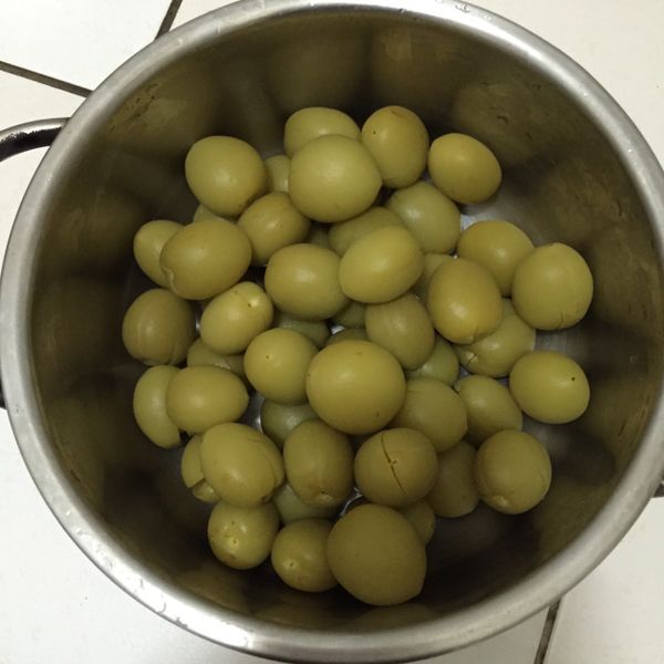 將搓揉完的青梅一一用空玻璃瓶敲裂（不需清洗，含有鹽巴敲裂即可），可以放在袋子裡一顆顆敲裂鹽巴才不會亂飛濺