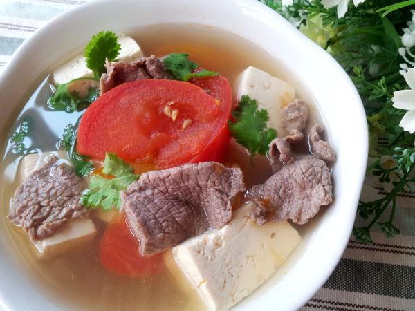 鍋子中加入800ml的清水 ; 再加入薑片煲滾 ; 開水滾了以後加入蕃茄 , 蓋上鍋蓋 ; 等到再次沸騰後加入豆腐 ; 煮約10分鐘