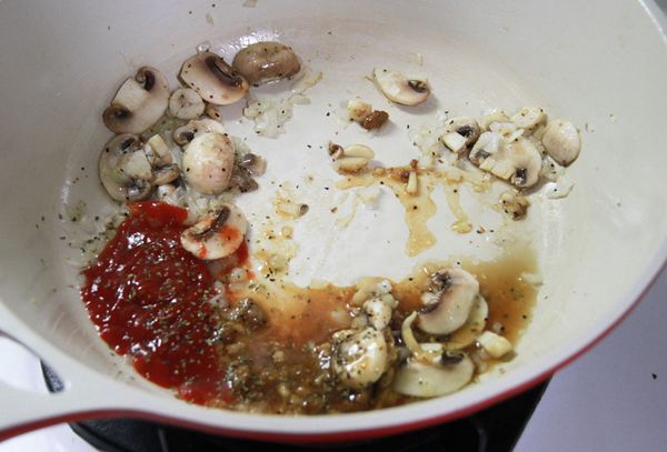 鍋加油炒香洋蔥碎、洋菇片，放入乾意麵肉醬、番茄醬、綜合香料、黑胡椒調味，加入意麵拌勻入味。