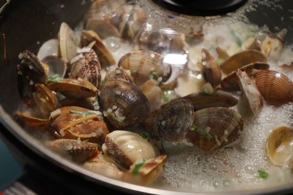 爆香辣椒末、蒜末以及蔥末後，加入海瓜子稍微翻炒後，倒入米酒並蓋上鍋蓋