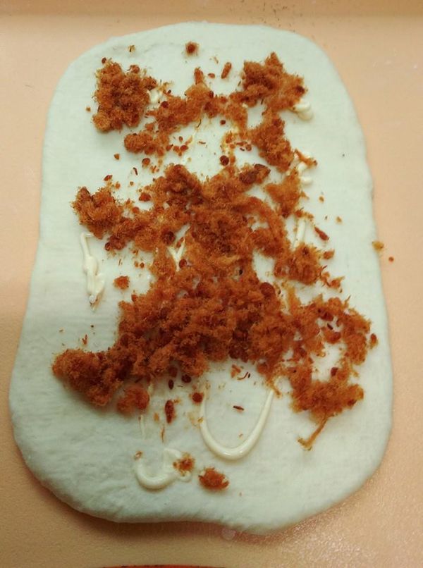 一發後麵糰分2糰分別滾圓鬆弛15分，每個麵糰桿長方形，上擠些沙拉醬.肉鬆舖上，由左至右捲呈長條形收口放下面