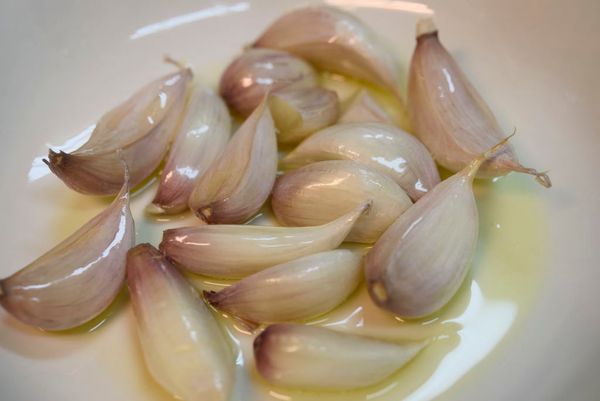 將蒜頭撥至瓣狀，洗淨後放入盤中，加入兩匙苦茶油扮一扮