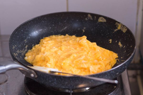 開中火，鍋中下油，油熱後轉到中慢火，倒入拌好之蛋漿，每看到底部結成薄薄一層蛋皮就推向中間（可用剷子或筷子），直到蛋漿不再流身如水狀，整個炒蛋大約五成熟左右（如圖）即可關火取起備用
（千萬不要不停撥散雞蛋，完成這個步驟之後應該為一大塊炒蛋）