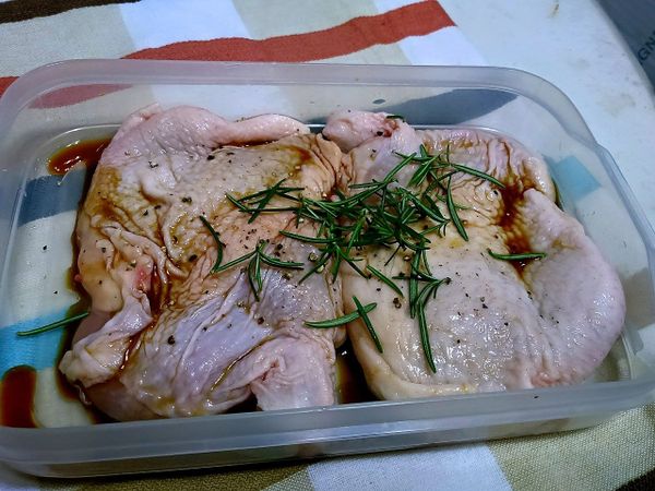 去骨雞腿肉置於可密封的容器中，摘下新鮮迷迭香再加入桔香醬油，按摩雞腿肉並將迷迭香均勻分布於雞腿肉上，放入冰箱冷藏一晚