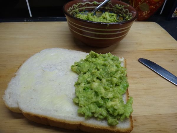 吐司先上一層牛油。將酪梨沙拉塗在半邊吐司上。