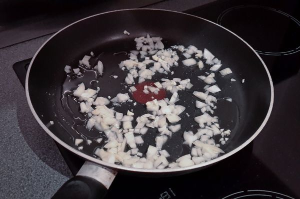 下橄欖油及蒜蓉，用小火煮兩分鐘，然後下洋蔥，炒兩分鐘至軟身