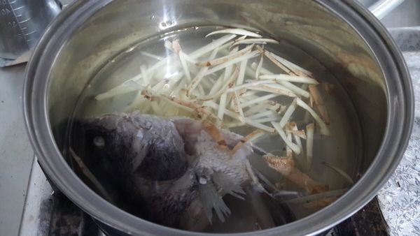 取一鍋子放入一半的水量加入老薑絲煮滾,放入魚頭再次煮滾