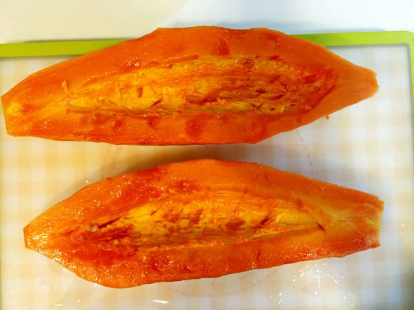 木瓜洗淨剖半，去籽去皮，背面靠中心部位削去一片，使木瓜可以平放