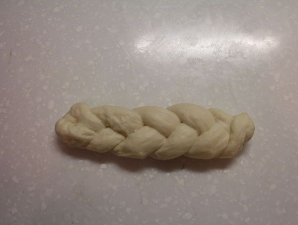 將長形麵條編成三股麻花辮。