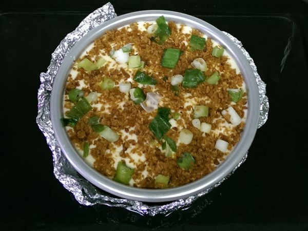 再倒入剩下麵糊，表面撒上魚(肉)鬆及蔥花，並將模型放在桌上敲2-3下，讓空氣排出