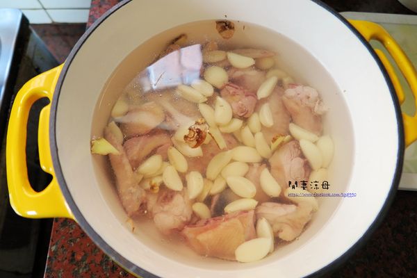 放入雞肉、蒜頭、米酒，開火煮約三十分鐘