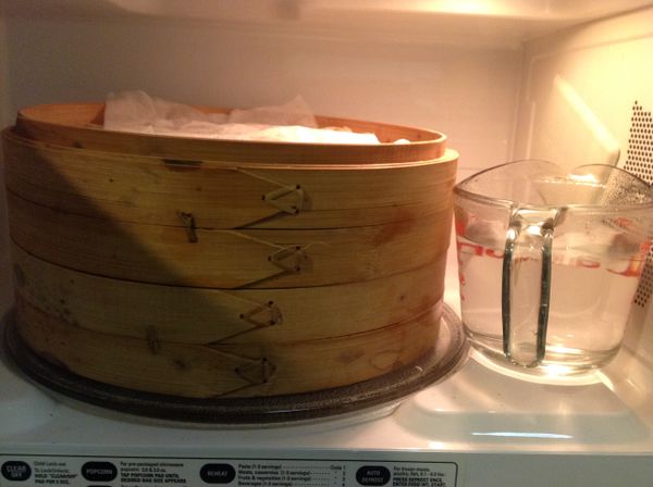 表面蓋上濕布或錫箔紙,放杯熱水在微波爐內或溫暖處.將8大個紫芋頭橘地瓜花花饅頭放進去,進行2次發酵約 15~20 分鐘