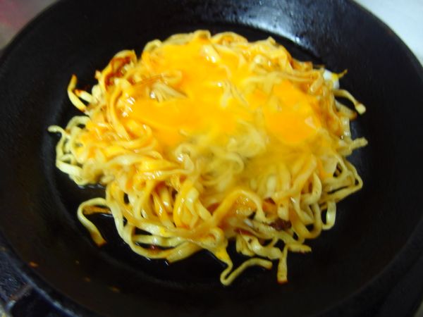 取一人份意麵至鍋中集成一個圓形~打一顆蛋~慢慢的煎 定形後翻面~
