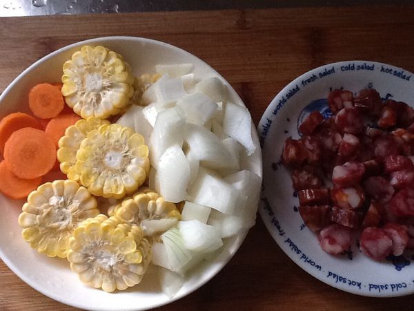 紅蘿蔔削皮切圓片，玉米切小圓段，臘腸切圓片，洋蔥切丁。