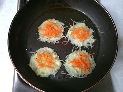 油鍋熱後加入一匙的馬鈴薯絲，
盡量將馬鈴薯絲攤開成薄片狀，
中間放上一些胡蘿蔔絲裝飾。