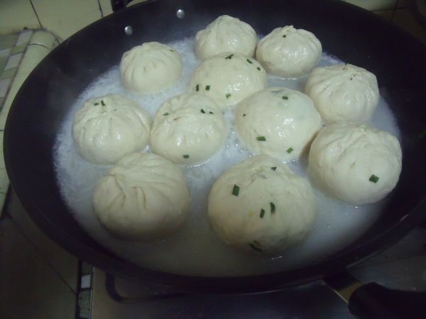 鍋中放入少許的油,放入煎包,煎至底部些許金黃,倒入麵粉水。