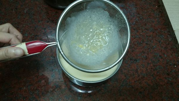 混合好的布丁液，慢慢過篩 2.3 次，把雜質去掉。把冷藏的焦糖模型拿出來，慢慢加入布丁液，約8分滿。
