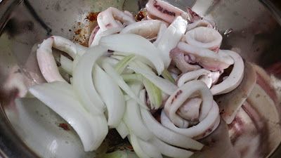 將切好的洋蔥跟川燙好的魷魚一同放入醬料的容器中。