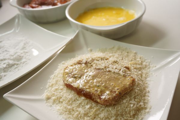 將蛋打勻，醃漬好的肉排先沾一層薄薄的低筋麵粉後沾上蛋液再沾麵包粉。