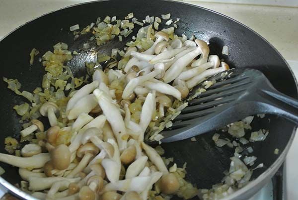 再加入鴻禧菇，炒5分鐘左右，直到鴻禧菇出水，此時加入蕃茄罐頭、鹽、黑胡椒。燉煮10分鐘。