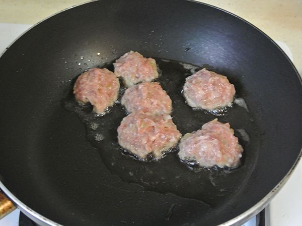 鍋中放3大匙油，熱鍋，小心的把肉丸子放進去，先不動它，直到一分鐘後，它已可以成形，再翻面煎到8分熟左右。