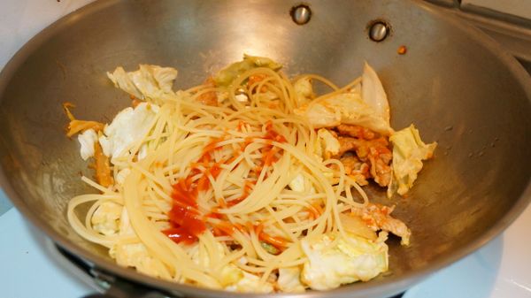將撈起的義大利麵放進鍋中拌炒，再淋上1大匙番茄醬和1茶匙橄欖油。醬汁完全包裹住麵條後，可以試試味道，不夠鹹可以放一點鹽，就不要再加番茄醬了。