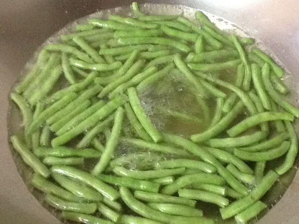 起一小鍋水，煮沸後加入少許油與鹽，放入四季豆川燙至轉綠熟透。