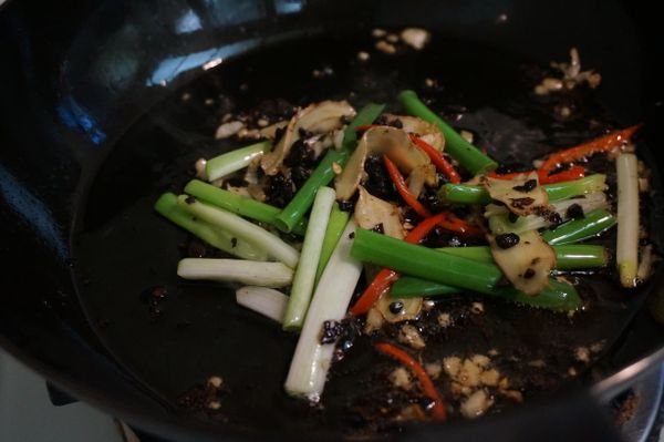 1-1/2大匙油熱平底鍋，依序將老薑片、蒜末、黑豆豉碎、青蔥段及辣椒絲下鍋炒出香氣後關火放涼。