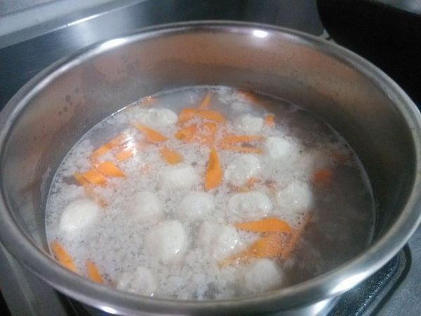 白米洗淨後，與魚丸、豬絞肉、紅蘿蔔一起放入鍋中，然後加入適量清水，先以大火煮至沸騰，然後轉中火。