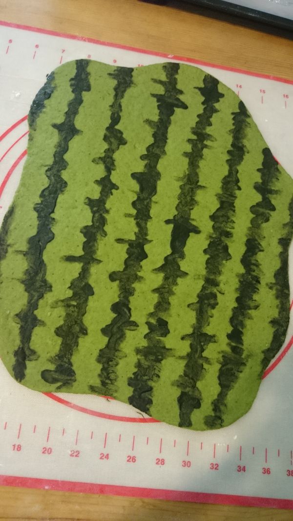 取出綠色麵團,用擀麵棍桿開成長方片狀 , 用毛筆沾取調好的"地瓜葉竹炭汁"畫出西瓜紋路後放置一旁讓線條乾燥固定.