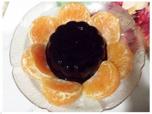 將橘子一瓣一瓣的擺放在龜苓膏旁