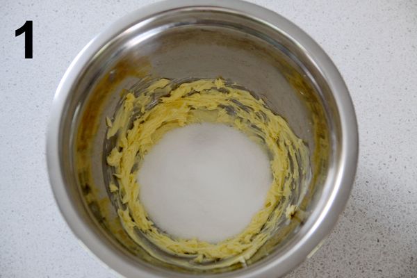 牛油軟化後，用打蛋器或攪拌器打發一下，加入細砂糖；
