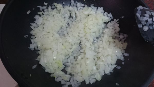 材料先準備好。洋蔥切小丁，放進炒鍋加少許油，中火炒到變軟變透明。(可加1小湯匙的水一起炒)