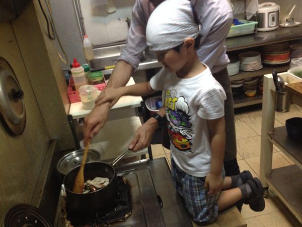 爸爸在一邊指導著李子先把香腸炒半熟